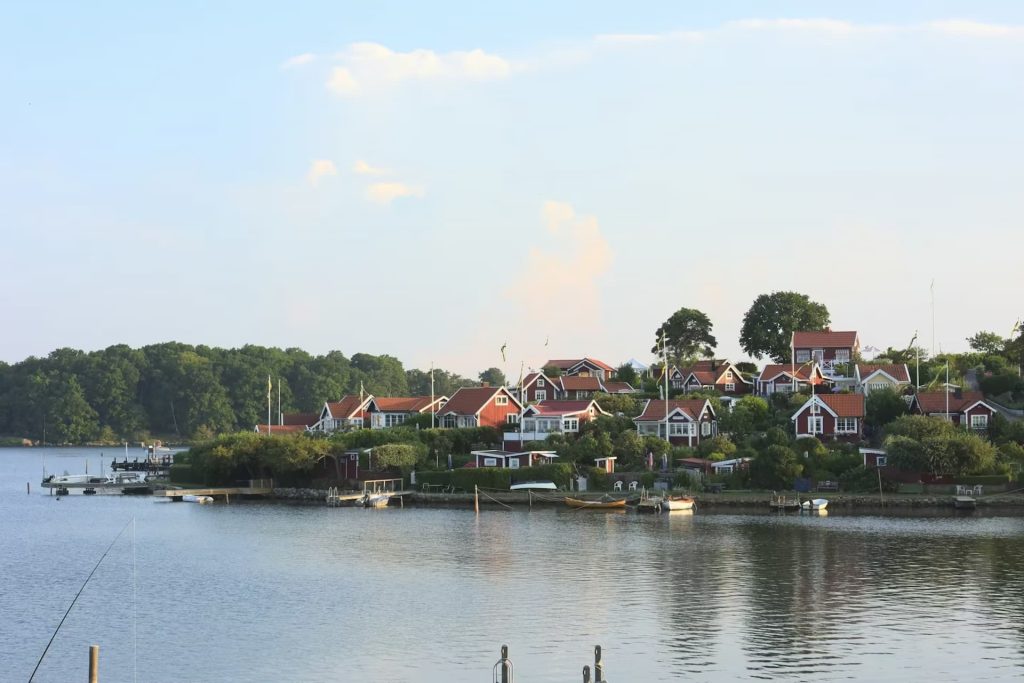Röda hus med tegeltak vid en lugn vik
